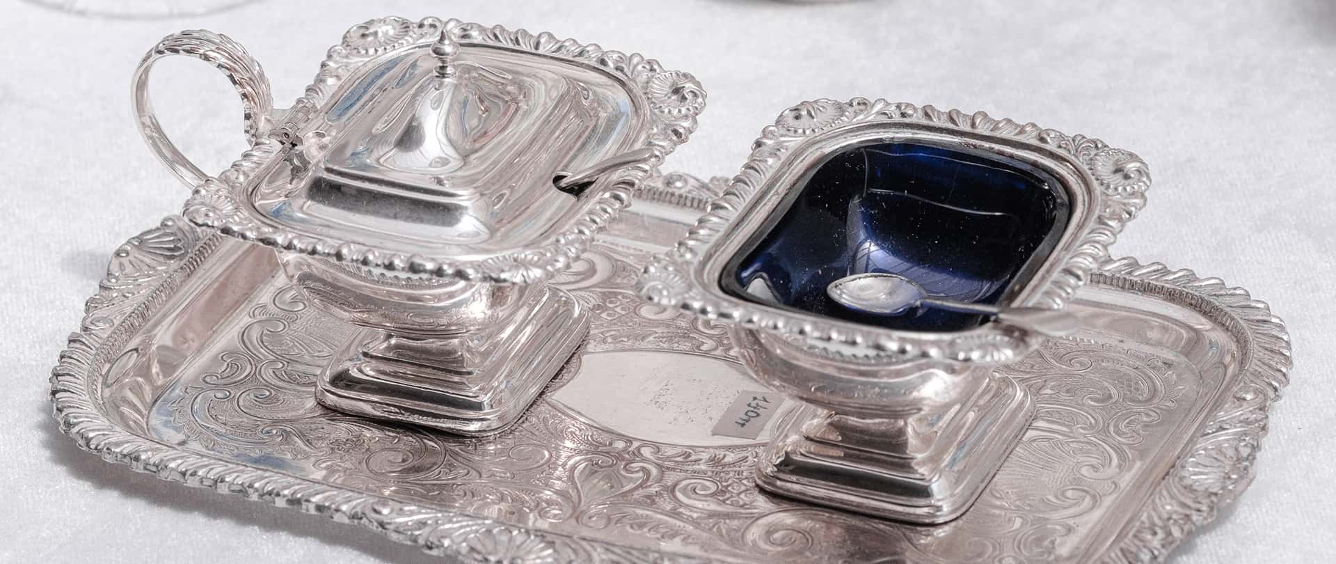 Portaghiaccio in argento finemente lavorato con lucida superficie riflettente e vaschette separate, eleganza classica per dessert o rituali.