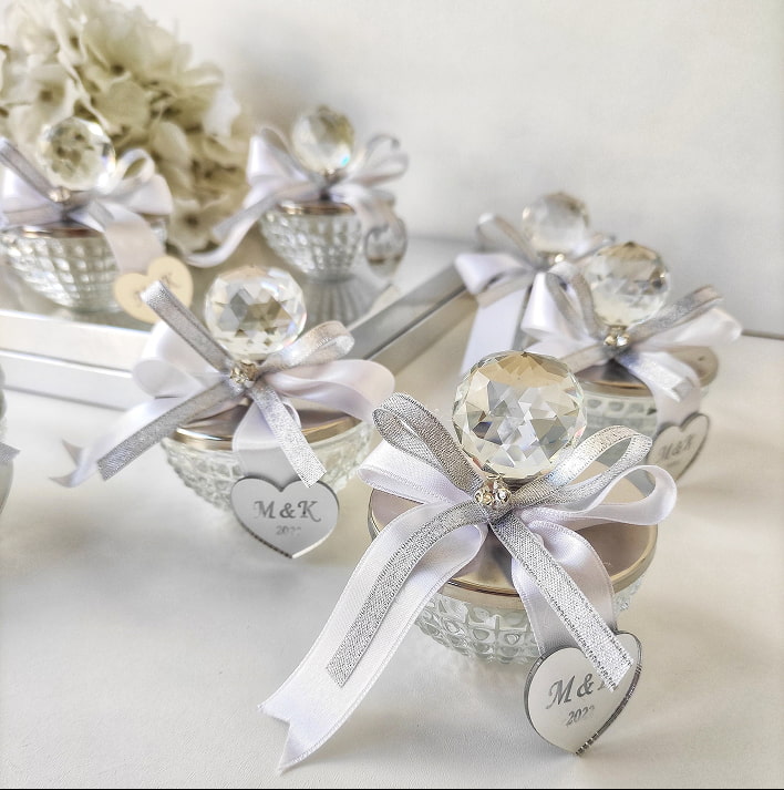 Contenitori decorativi bianchi con nastro argento, fiocchi e cuori decorativi, effetto romantico e luminoso per occasioni speciali.