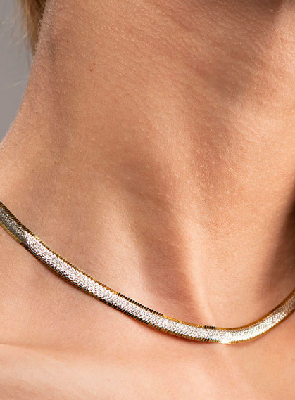 Elegante collana a maglia piatta in oro giallo e bianco indossata, girocollo di lusso Micheletti Gioielli