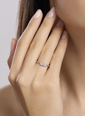 Anello sottile con pietra brillante posizionato su dito anello, primo piano su mani e unghie ordinate