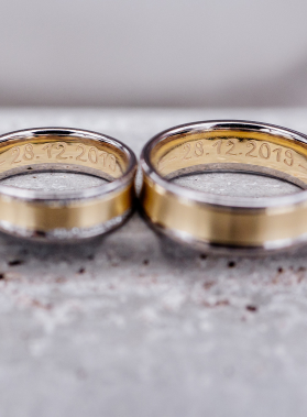 Anelli intrecciati in primo piano su sfondo neutro, data incisa 28.12.2019, simbolo di matrimonio e unione duratura.